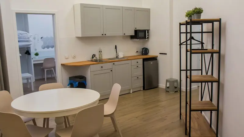 Jadalnia z okrągłym stołem i sprzętami w rogu.