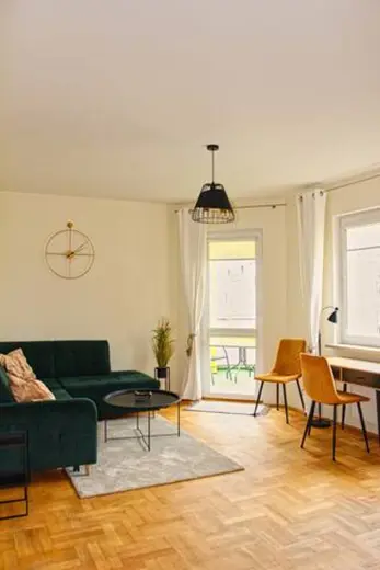 Salon z zieloną sofą, stolikiem i roślinami