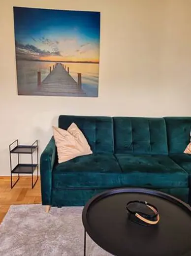 Salon z turkusową sofą i obrazem nad ścianą
