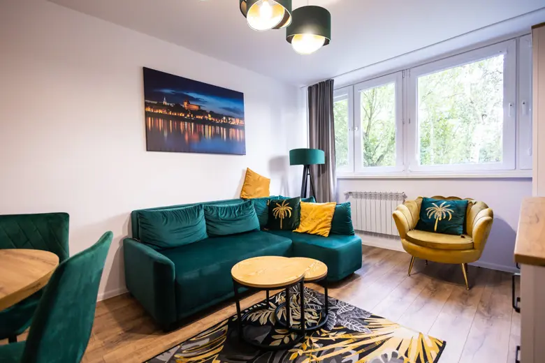 Salon z zieloną sofą, żółtymi poduszkami i lampą