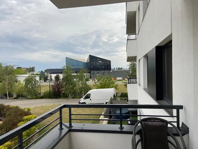 Widok z balkonu na osiedlowe budynki i parking