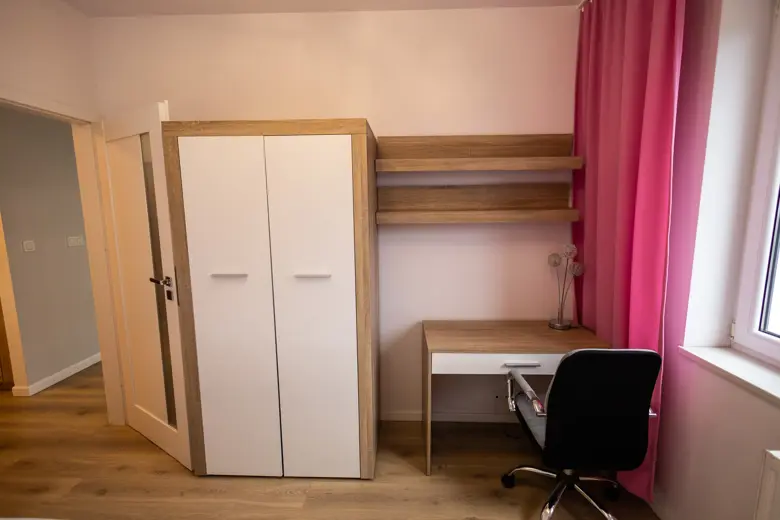 Kącik do pracy z biurkiem i krzesłem przy oknie.