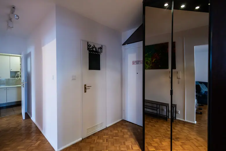 Wejście do mieszkania z lustrzanymi drzwiami i parkietem