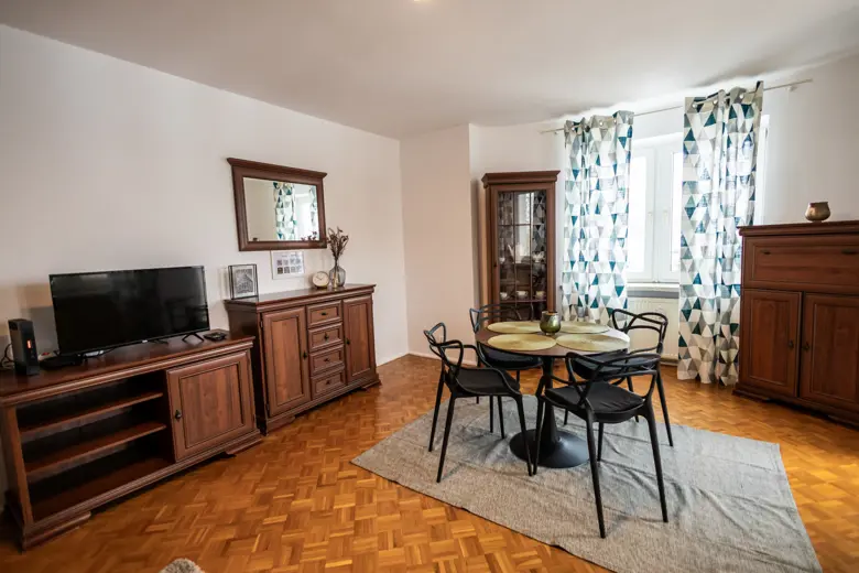 Widok na salon z sofą i zestawem jadalnianym