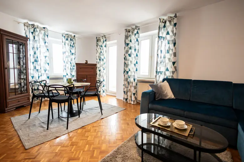 Salon z sofą i zestawem mebli drewnianych, telewizor