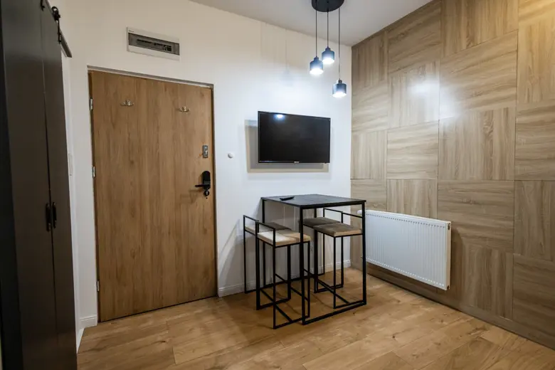 Minimalistyczny kącik jadalny przy ścianie z panelami.