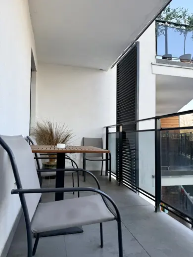 Mały balkon z krzesłami i stolikiem, widok z zewnątrz
