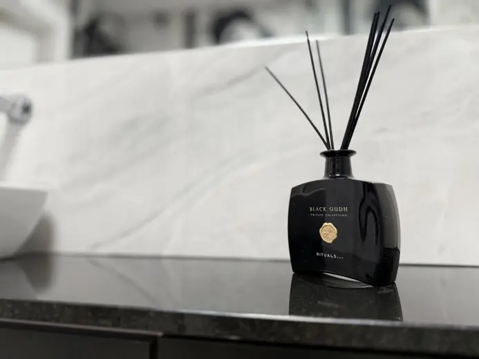 Czarny diffuser z patyczkami na granitowym blacie