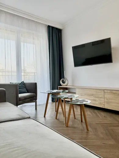 Telewizor na ścianie nad komodą w salonie