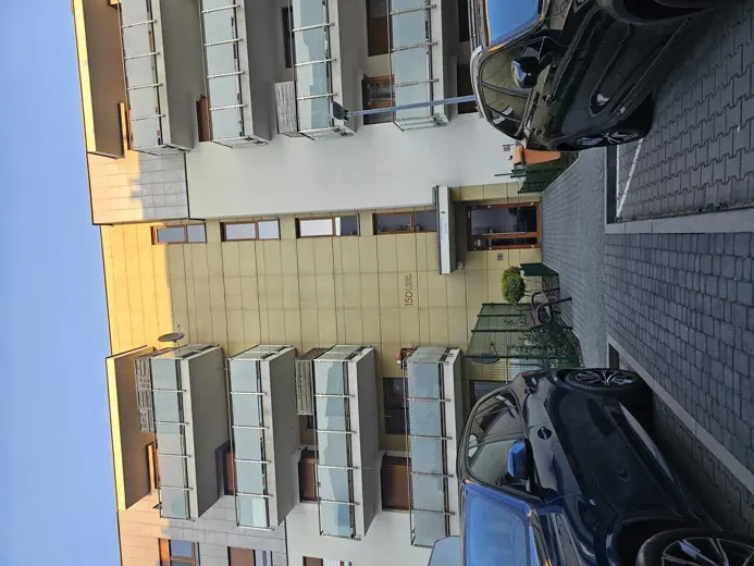 Widok na zewnętrzną elewację budynku i parking