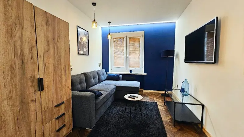 Salon z sofą narożną i niebieską ścianą