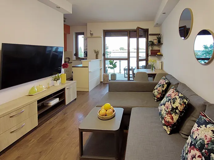 Salon z dużą sofą, telewizorem i konsolą dekoracyjną