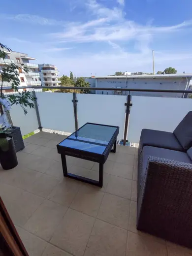 Balkon z sofą, stolikiem i widokiem na zewnątrz