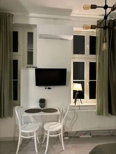 Jadalnia z dwoma krzesłami i telewizorem na ścianie