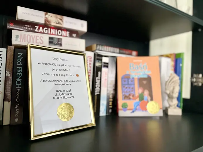 Półka z książkami i wyróżniającą się tabliczką.