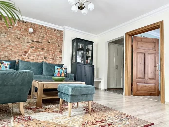 Przestronny salon z ceglastą ścianą i sofą.