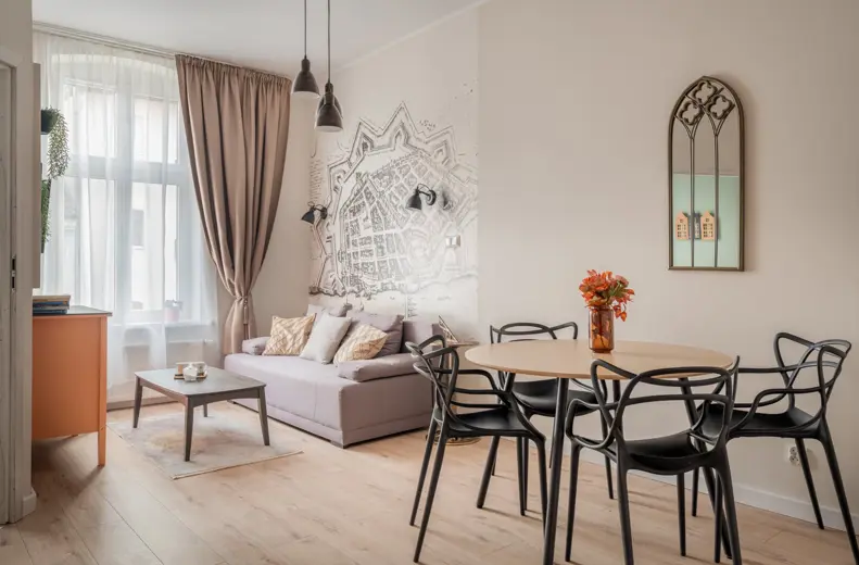 Salon z sofą przy dużym oknie i dekoracją na ścianie