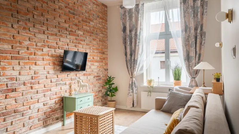 Salon z kanapą przy oknie i roślinami na parapecie