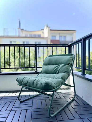 Balkon z zielonym, wygodnym fotelem