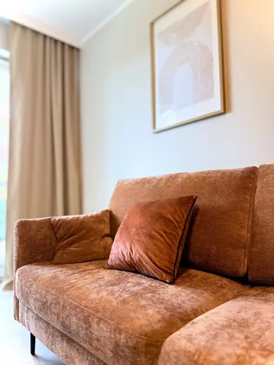 Sofa w kolorze budyniowo-brązowym z miękkimi poduszkami