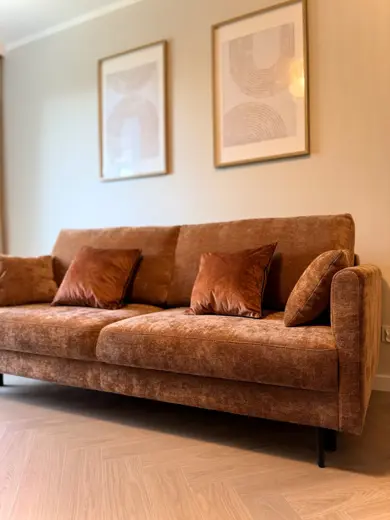 Duża brązowa sofa w jasnym salonie