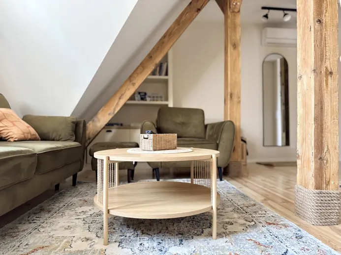 Kadr z salonu z belkami drewnianymi i sofą