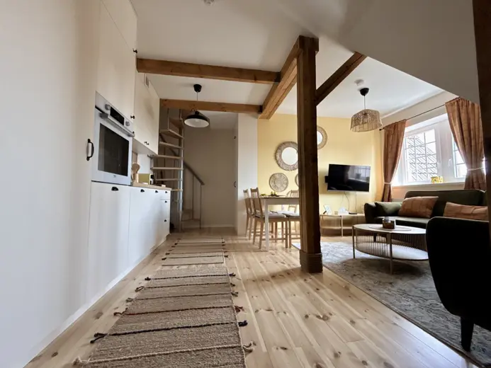 Salon z belkami drewnianymi, część jadalniana i sofa