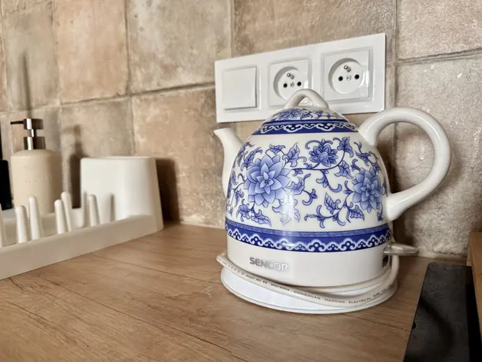 Czajnik ceramiczny z niebieskim wzorem na drewnianym blacie
