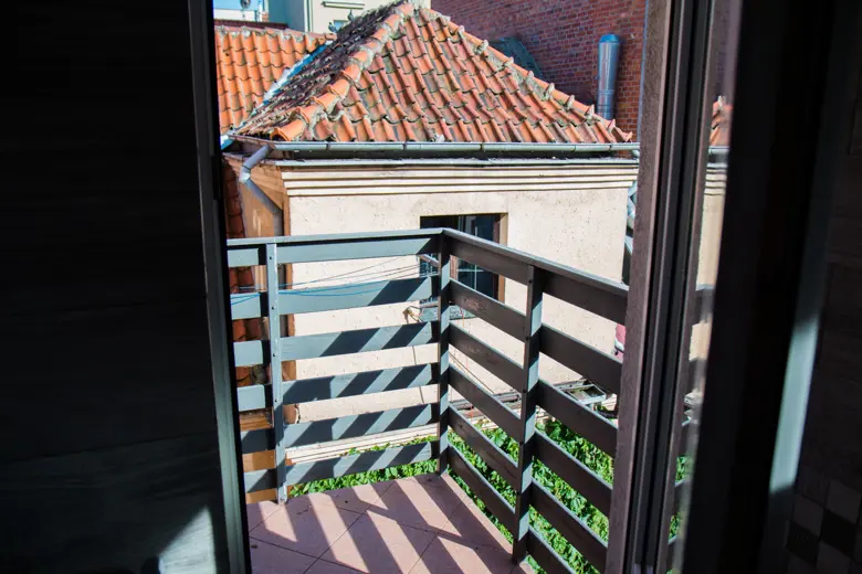Balkon z widokiem na dachy miasta.