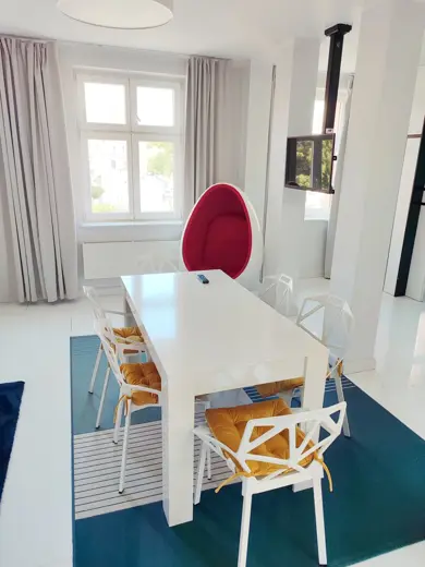 Salon z kanapą, dużymi oknami i galaktycznym obrazem na ścianie