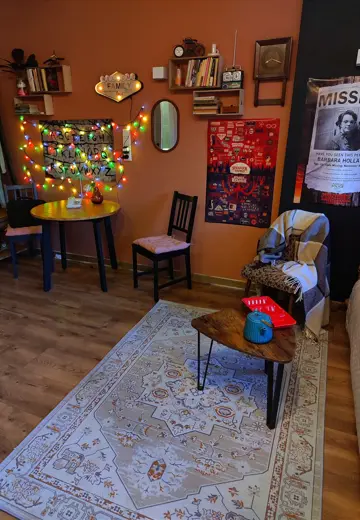 Salon z girlandami, okrągłym stolikiem i miękkim dywanem