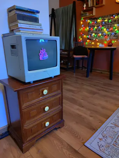 Stary telewizor na drewnianej szafce z książkami na górze
