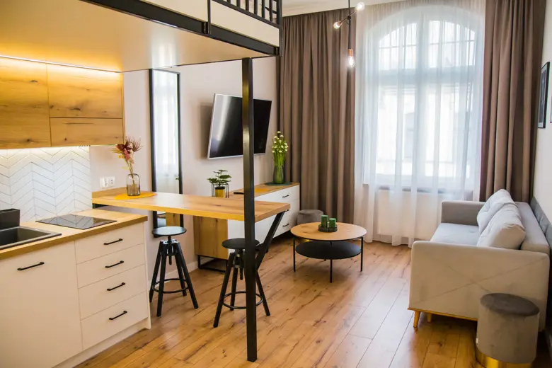 Salon z sofą, dużym oknem i stołem kawowym, drewnianą podłogą