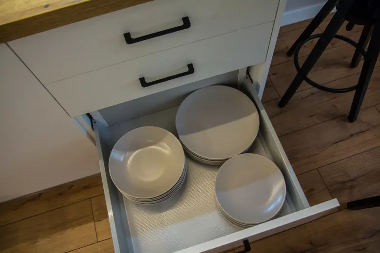 Szuflada z porcelanowymi talerzami i miseczkami, ułożona prosto
