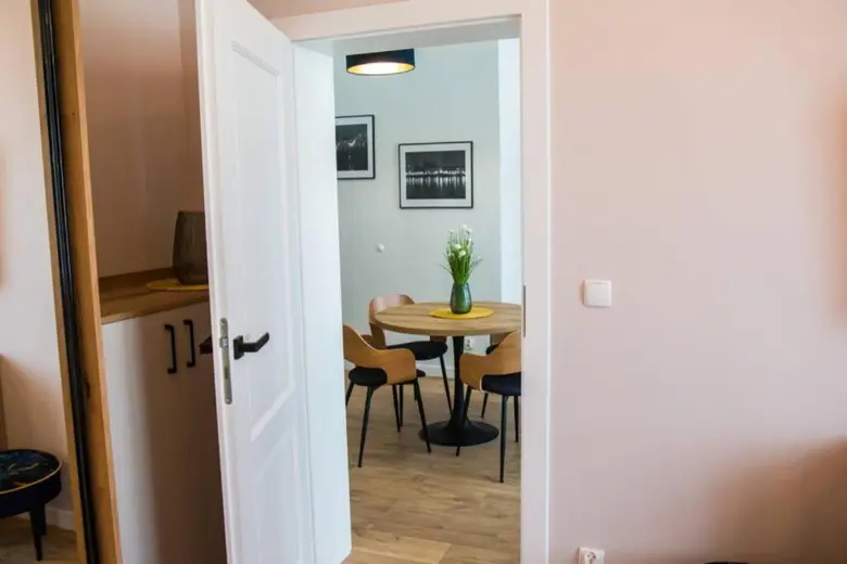 Wejście do jadalni, okrągły stół i żółte podkładki