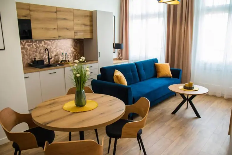 Salon z niebieską sofą i okrągłym stolikiem
