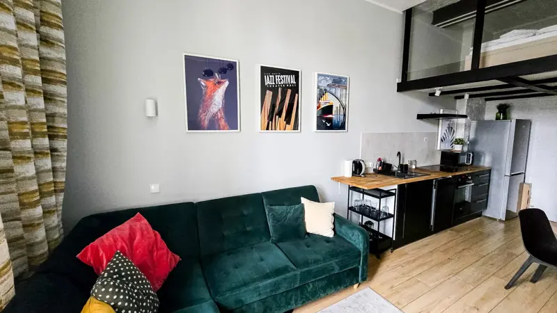 Sofa w salonie pod ścianą z trzema obrazami nad nią